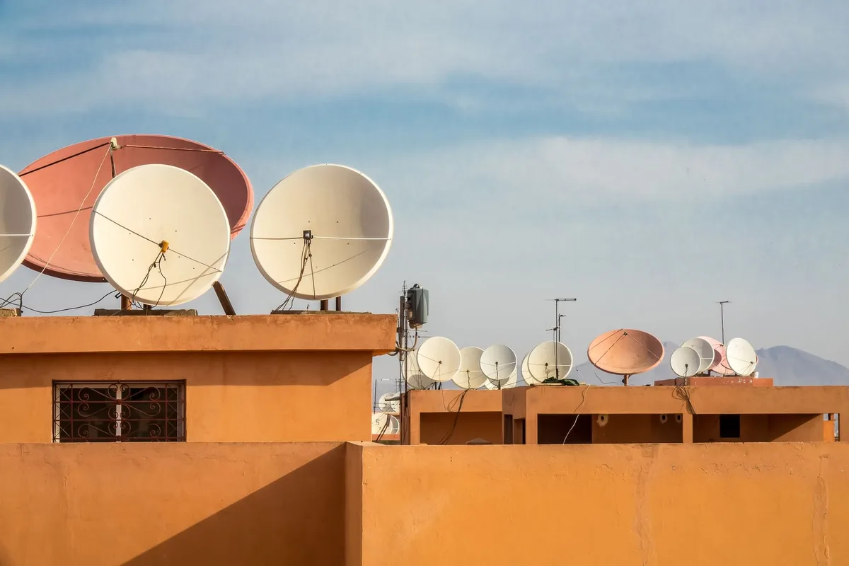 Bina çatısında sıralanmış çanak antenler — kutulu Digiturk paketlerinde uydu yayını